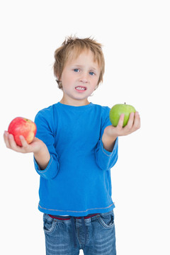 拿着红苹果和绿苹果的可爱小男孩