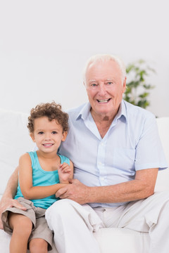 爷爷抱着孙子坐在沙发上