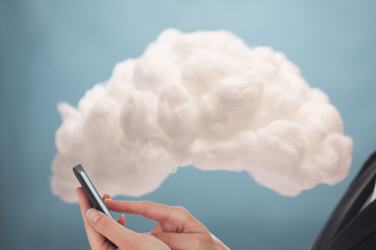 商人手机连接蓝色背景的云计算