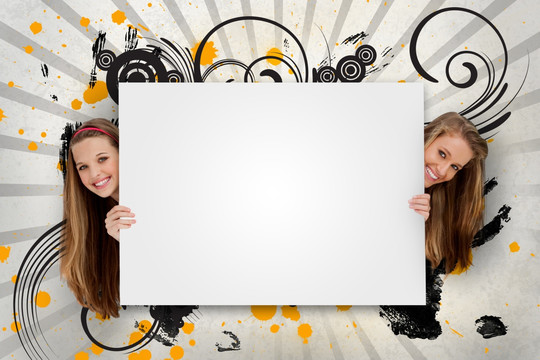 两个女孩躲在白色挡板后面微笑