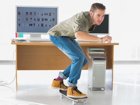 在办公室玩滑板的男子
