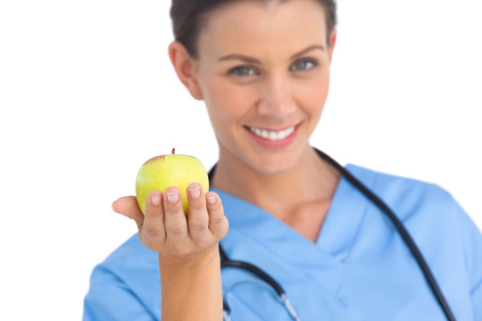 快乐的外科医生拿着一个苹果微笑