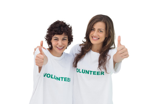 两个微笑的志愿者竖起大拇指