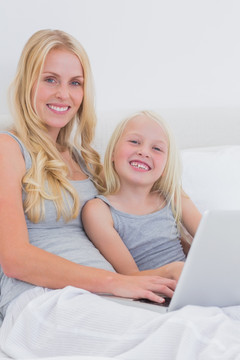 母亲和女儿使用笔记本电脑
