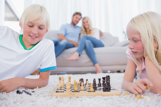 孩子们在他们的父母面前下棋