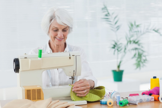 使用缝纫机的退休妇女