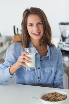 漂亮的女人拿着一杯牛奶