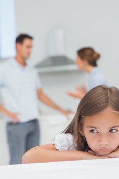心烦意乱的小女孩在听父母吵架
