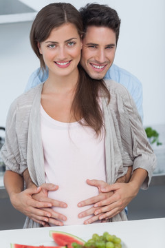 男人抱着他怀孕的妻子的肚子