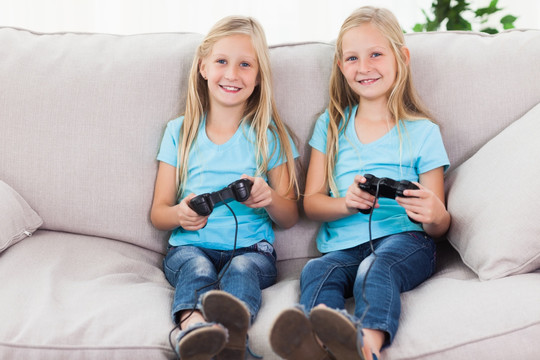 双胞胎的肖像一起玩视频游戏