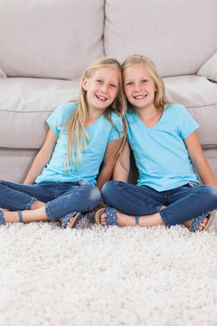 年轻的双胞胎坐在地毯上
