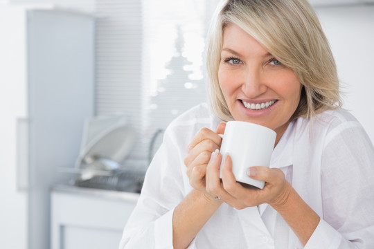 快乐的女人在早晨喝咖啡