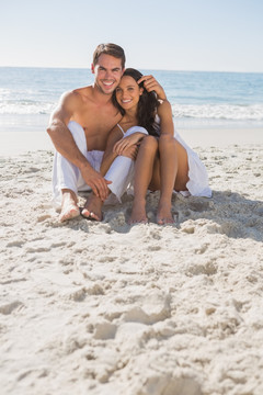 拥抱的夫妇坐在沙滩上