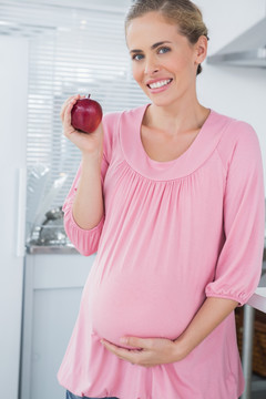 拿着一个苹果的孕妇