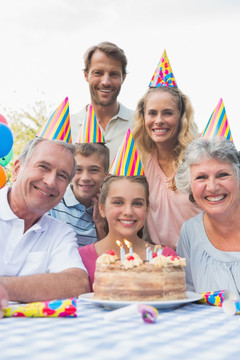 一家人在生日蛋糕前微笑