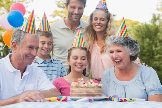 一家人在生日蛋糕前微笑