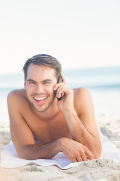 在海滩上打电话的男人