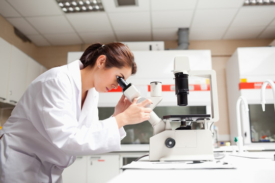 女科学家在实验室里看显微镜