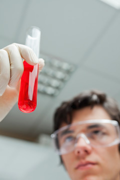 科学家拿着装满红色液体的试管