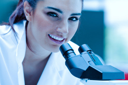 年轻科学家在显微镜前微笑