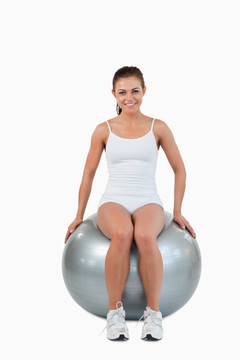一个快乐的女人坐在健身球上