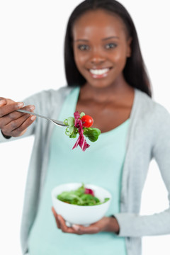 微笑的年轻女子手拿蔬菜沙拉