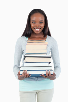 微笑的年轻女子捧着一堆书