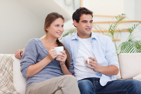 夫妻俩在客厅里喝茶的时候看电视