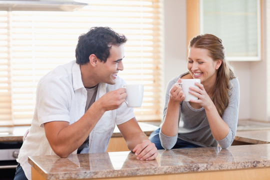 年轻夫妇在厨房里喝咖啡