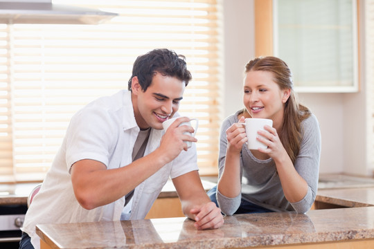 年轻夫妇在厨房里喝咖啡