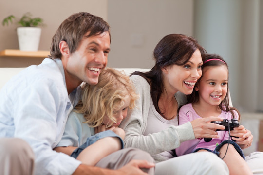 高兴的家人在客厅里玩电子游戏