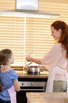 微笑的母亲在教孩子做菜