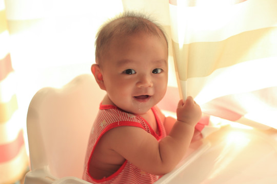 婴儿很有力量抓着窗帘嚣张的笑