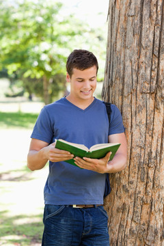 年轻人在公园里读一本书