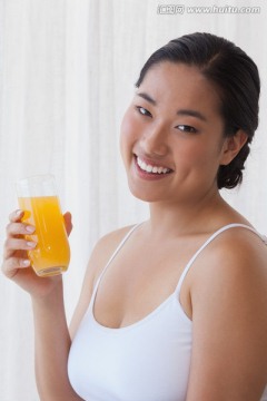 女人拿着杯橙汁微笑着