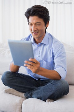 微笑着玩着平板电脑的男人