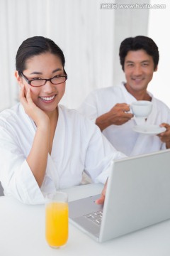 夫妇微笑着看着笔记本电脑