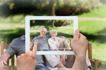 手持平板电脑给一对老夫妇拍照