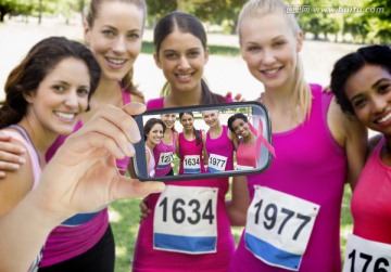 手持智能手机的女运动员们自拍