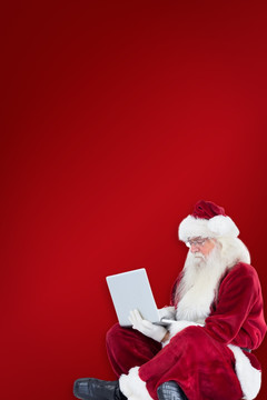 圣诞老人坐地上玩电脑的复合形象