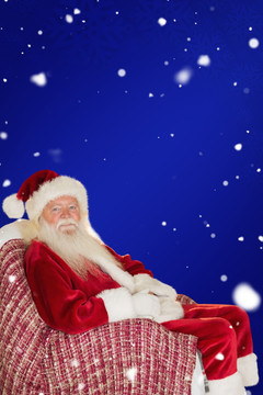 微笑圣诞老人坐在扶手椅上