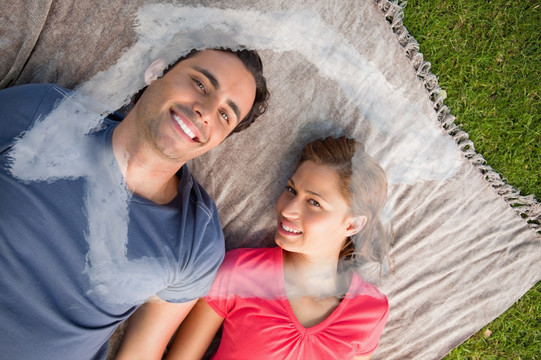 夫妇躺在草地上微笑着的复合形象