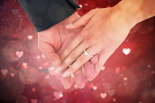 夫妇戴着结婚戒指拉手的复合形象