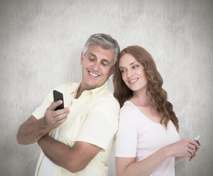 夫妇微笑着看着手机的复合形象