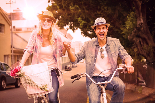 夫妇微笑着骑自行车的复合形象