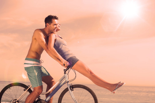 夫妇在海边骑自行车的复合形象