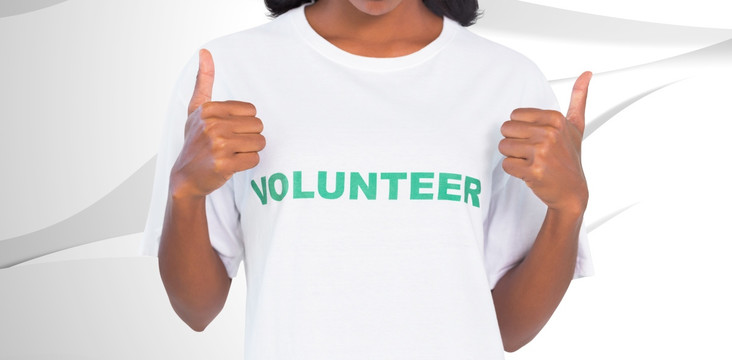 女人穿着志愿者T恤和伸出大拇指