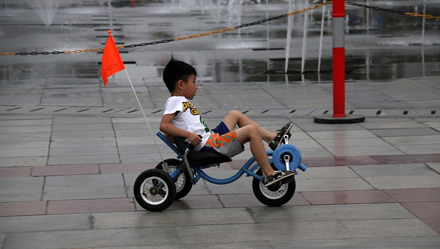 广场上骑车玩耍的孩子
