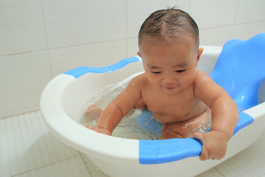 胖胖的婴儿坐在洗澡盆里玩耍