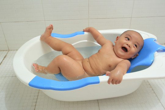 胖胖的婴儿洗澡躺着仰头大笑
